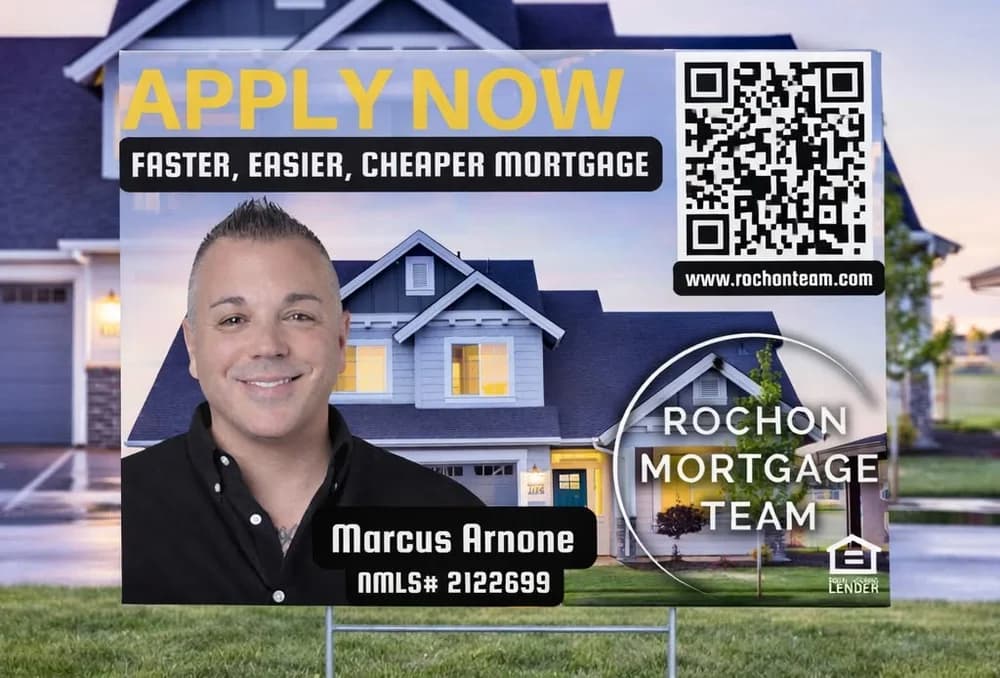 Yard sign for Rochon Mortgage Team in front of a house, with an APPLY NOW headline, a loan officer's photo, a QR code and the Equal Housing Lender mark.